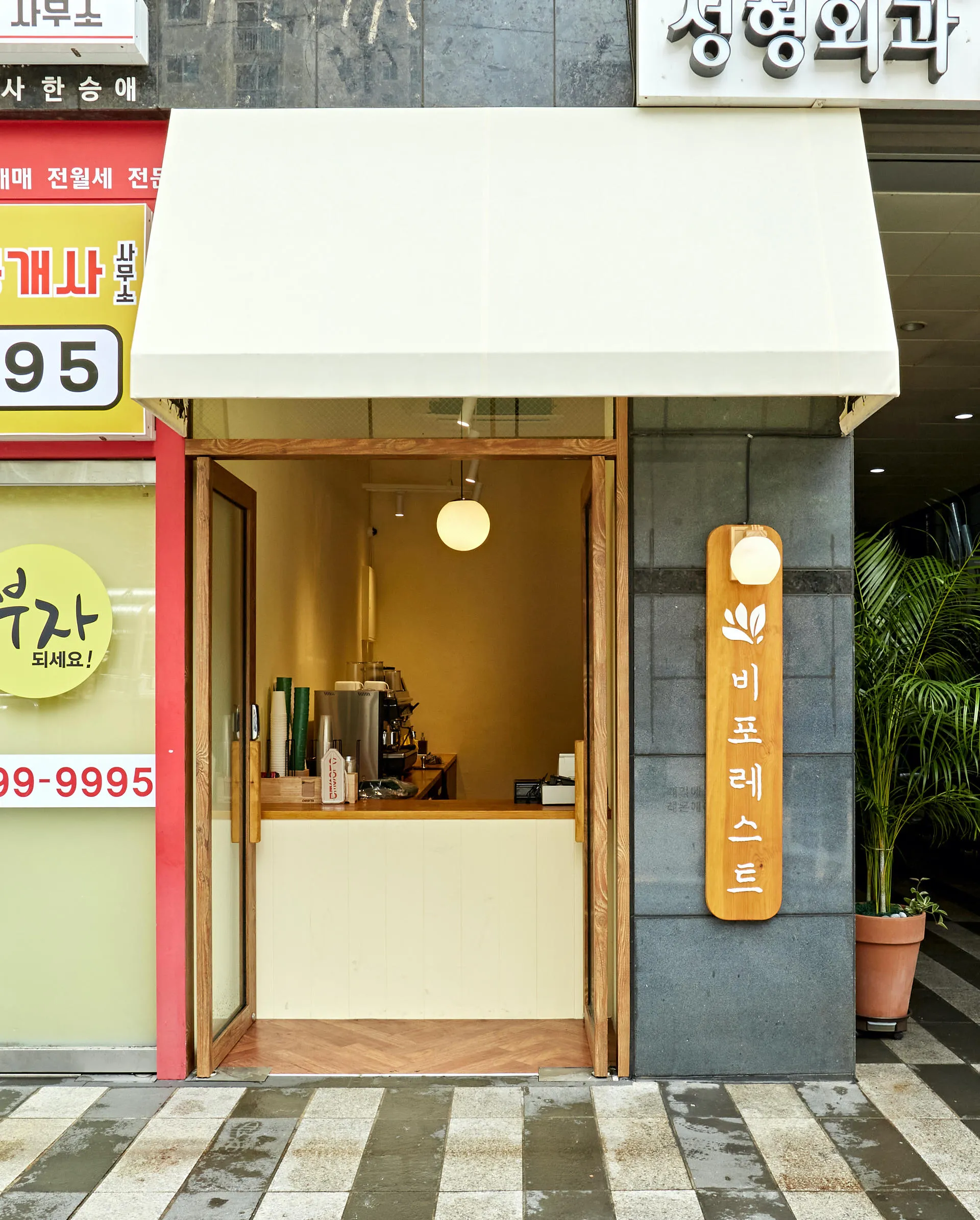 카페 비포레스트 노란 벽의 좁은 실내와 원목 세로 간판