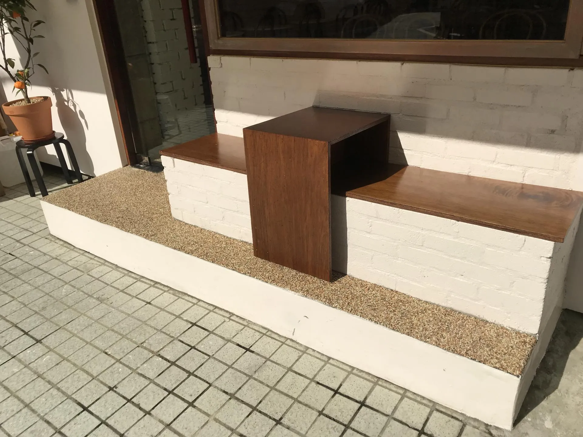 카페 서리풀 기단에 짜 넣은 원목 벤치와 자갈 마감 바닥