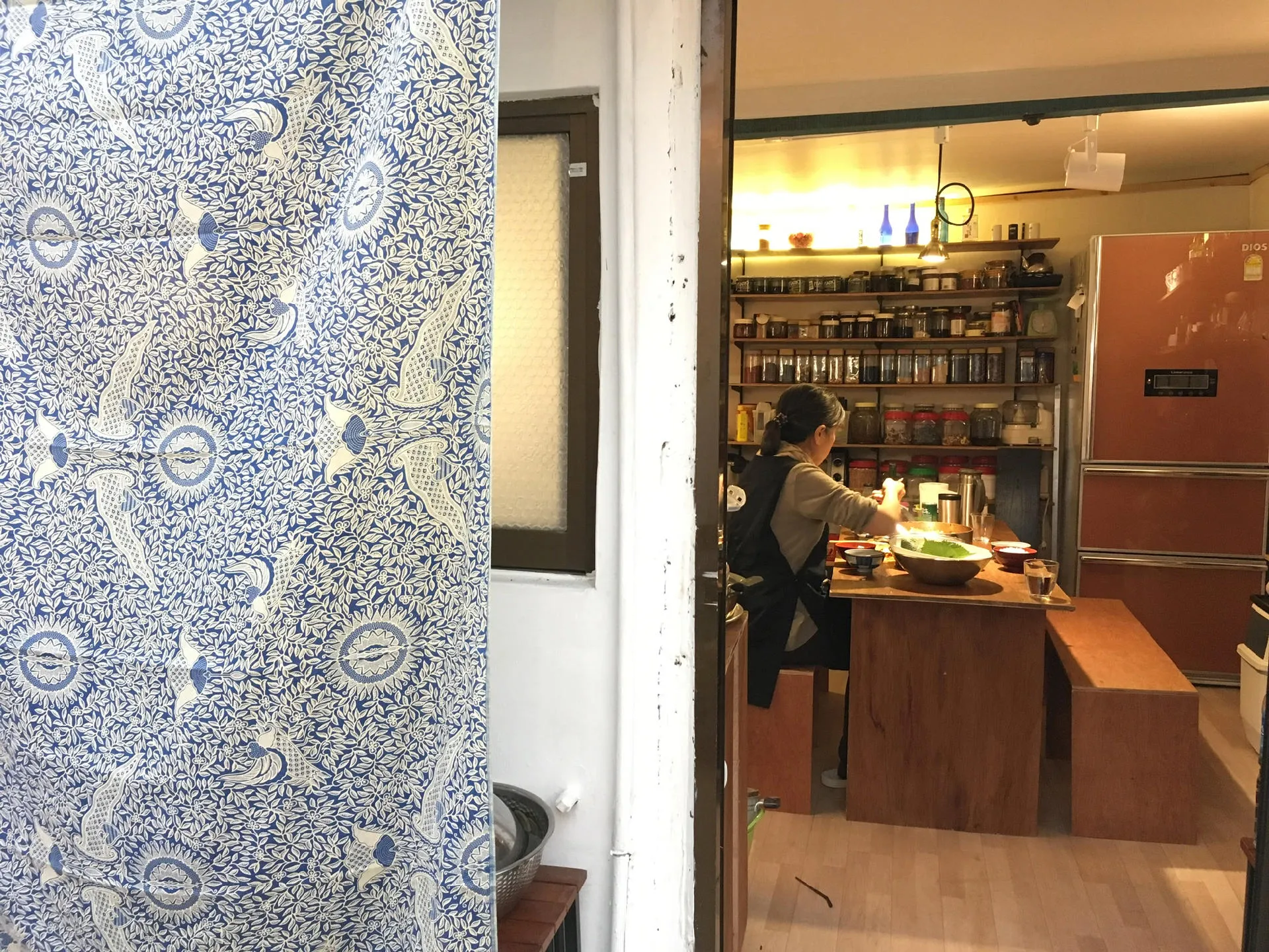 공간 순숨 문틈으로 보이는 주방과 원목 아일랜드